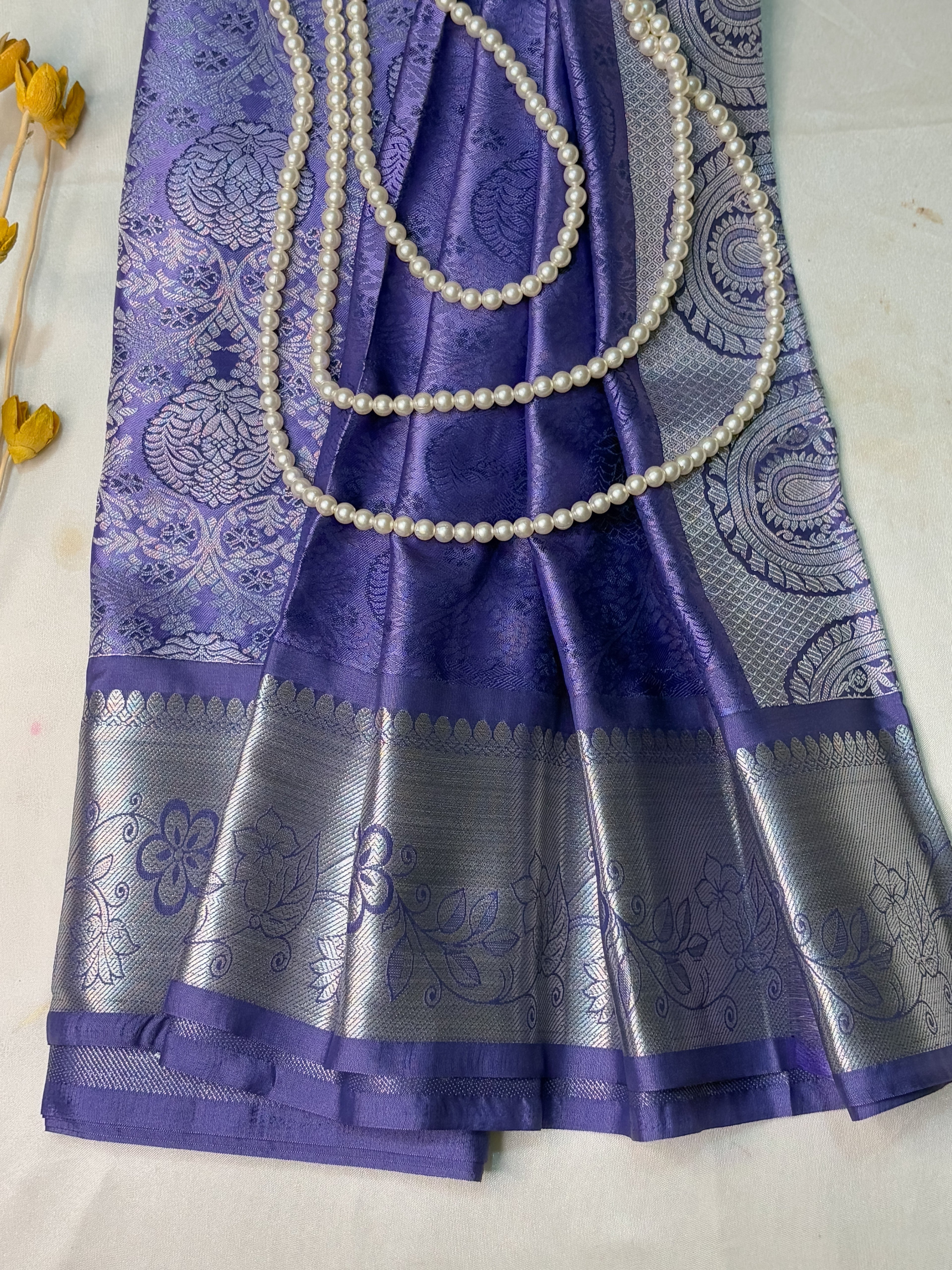 Purple saree with silver border and pearl border on a white background