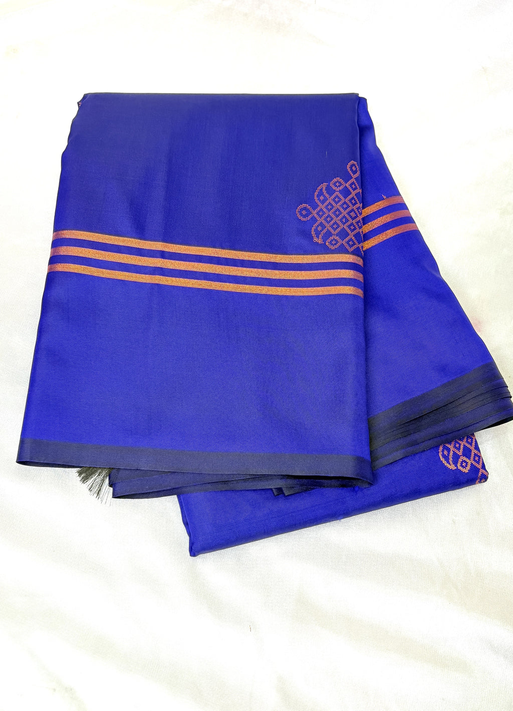 Blue saree with gold kolam on a white background