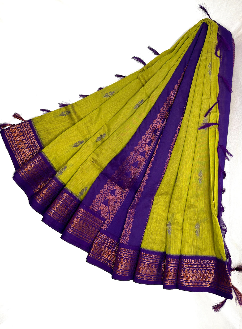 Green and purple saree with intricate patterns on a white background