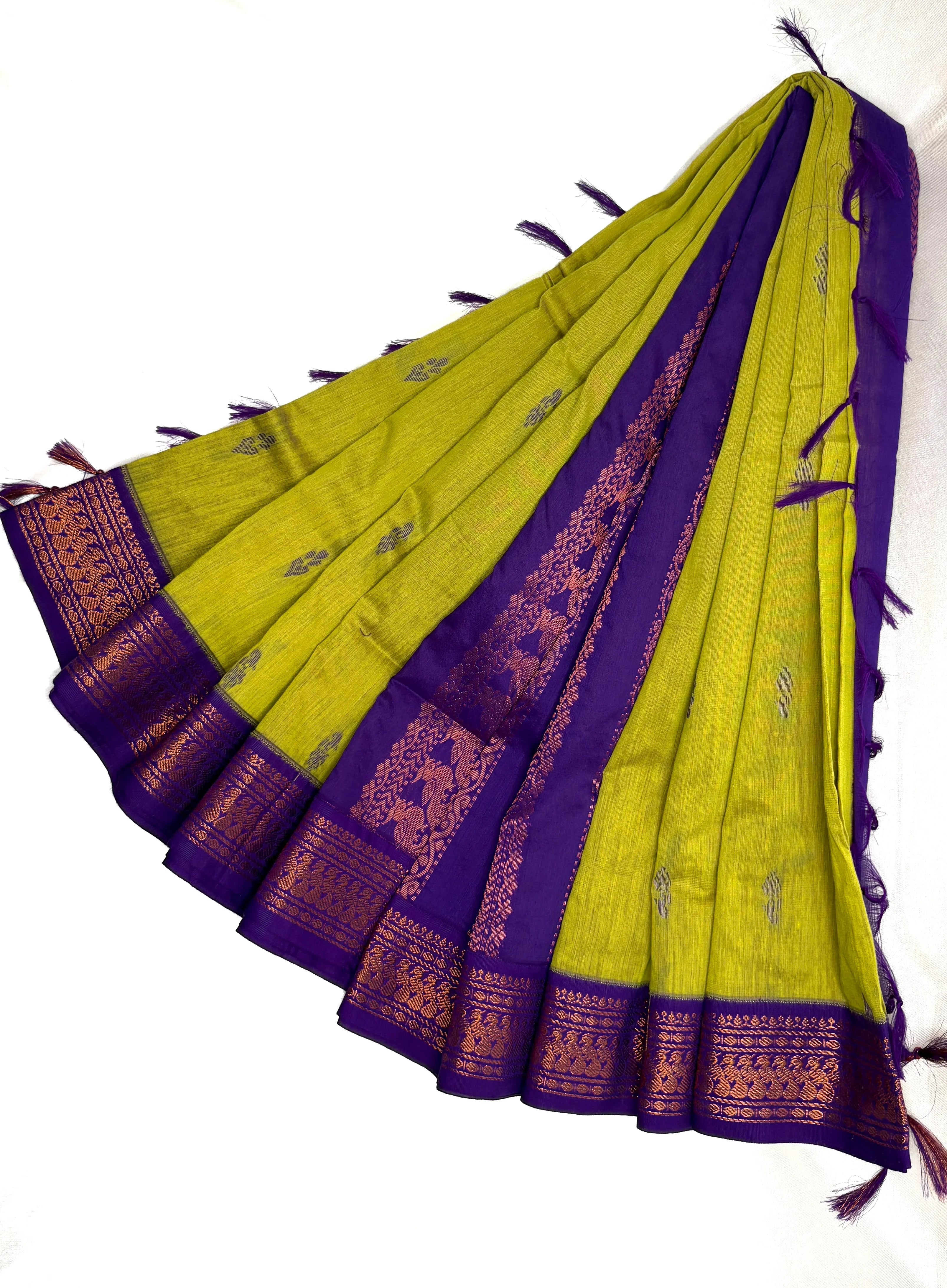 Green and purple saree with intricate patterns on a white background