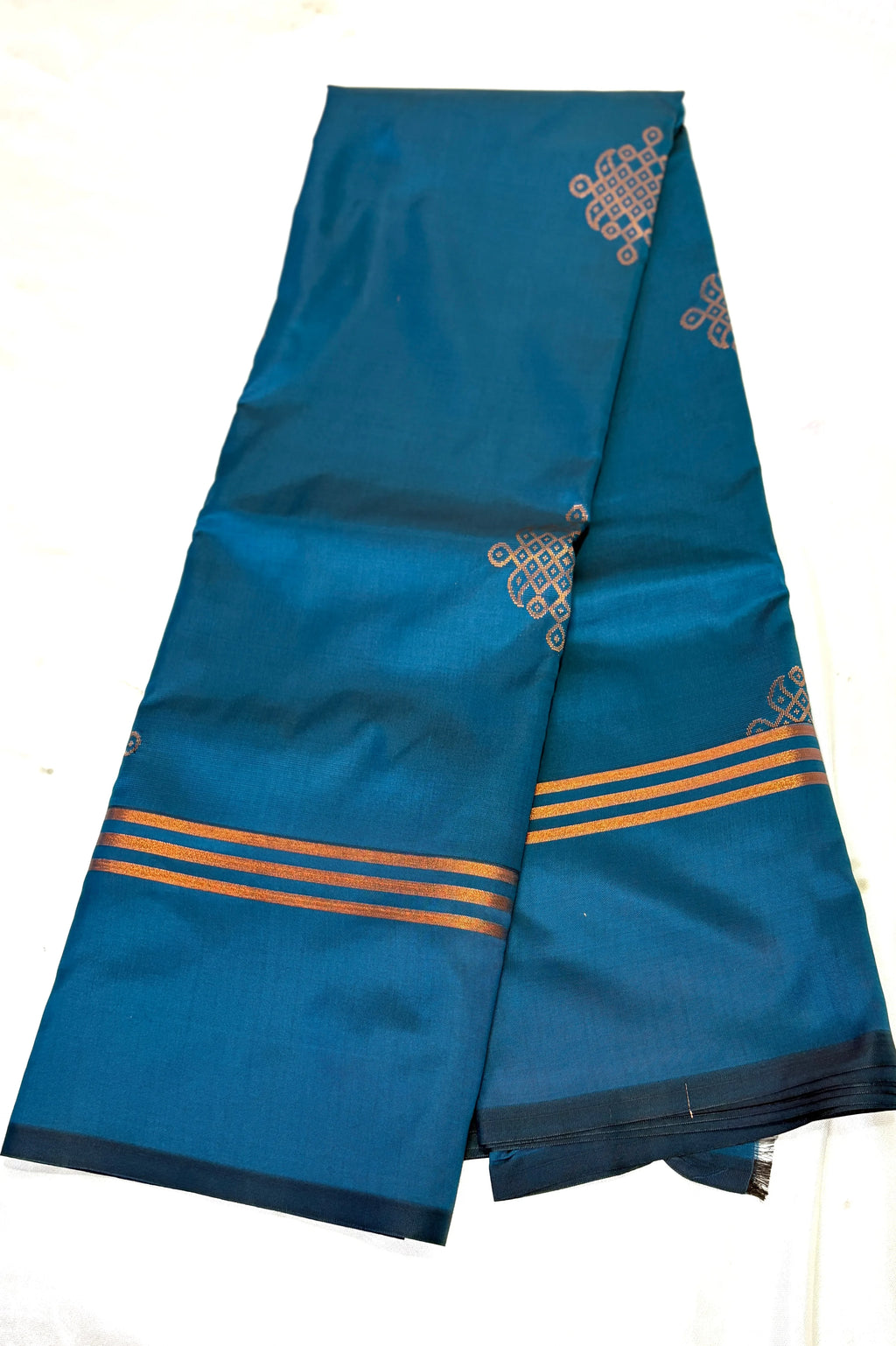Blue saree with gold patterns with kolam on a white background