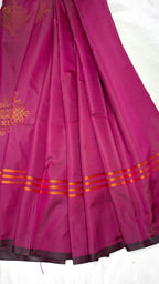 Pink saree with gold kolam patterns and border on a white background